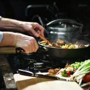 Person cooking food in a frying pan