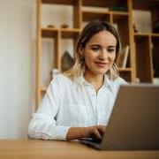 Person smiling and working on a laptop