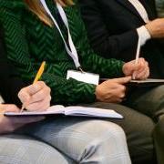 Attendees listen in and take notes during a speaker session